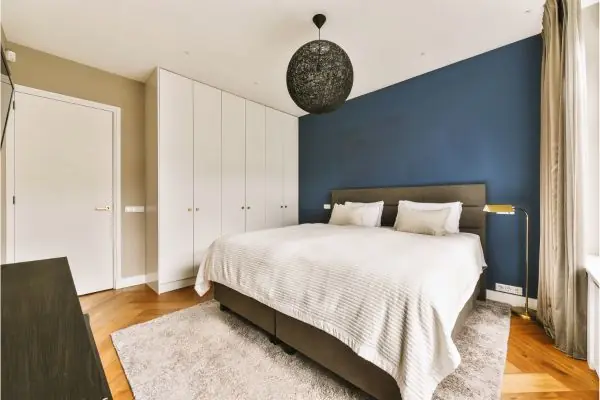 a bedroom with a bed and a blue accent wall