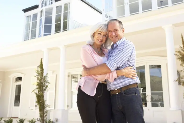 senior couple standing outside dream home